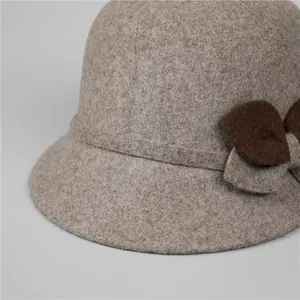 Dettaglio cappello in lana da donna con fiocco di peluche marrone e caldo tessuto invernale