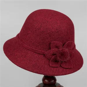 Detail view of burgundy wool cloche hat with fabric flower and soft pompom decoration