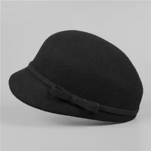 Detailed close-up of a black wool cloche hat featuring an elegant side ribbon and bow detail