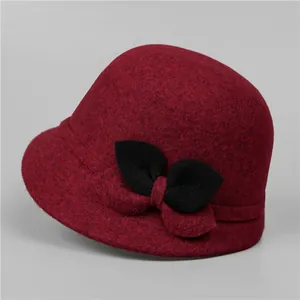 Dettaglio della trama del cappello cloche in lana rosso scuro per donne con fiocco nero