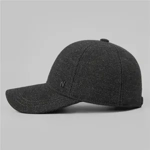 Detail view of the thick wool fabric texture and metal N logo on the men's winter cap