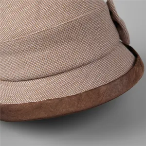 Close-up of winter cloche hat showing beige brown checkered fabric and faux suede brim