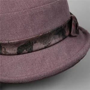 Detail of purple winter bucket hat featuring floral ribbon trim and bow accent