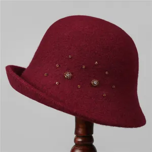 Details von weinrotem Wollhut mit Blumen-Strasssteinen und bernsteinfarbenen Perlen