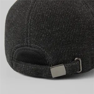 Detail of grey wool blend winter cap featuring a metal buckle and thick knit texture