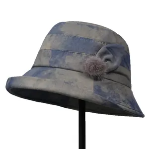 Elegant bucket hat for women with blue marble texture and soft fur pompom decoration