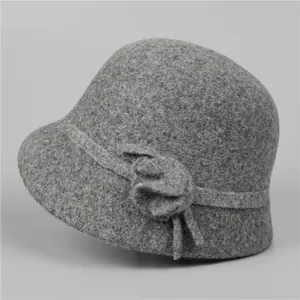 Detail of wool cloche hat with grey felt fabric and a 3D floral accent for women
