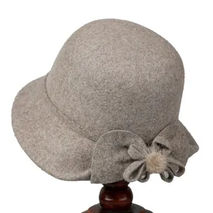Elegant wool felt cloche hat for elderly women featuring a side bow and plush pom-pom detail