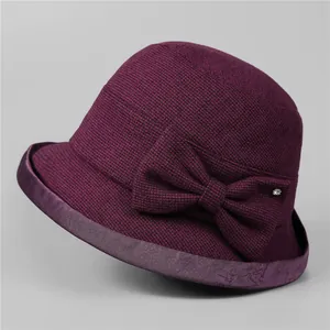 Detail of purple knitted bucket hat with velvet bow, rhinestone, and jacquard brim texture