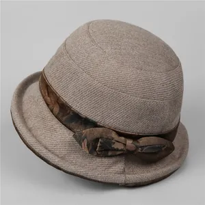 Detail of vintage wool cloche hat showing brown floral ribbon and decorative bow accent