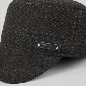 Detailed macro of dark grey wool fabric with FASHION leather label and rivets on cap