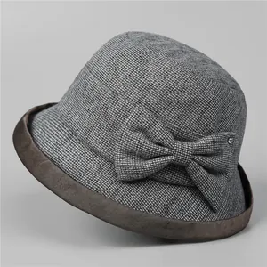 Detail of wool cloche hat for elderly women with bow accent and rhinestone on grey background