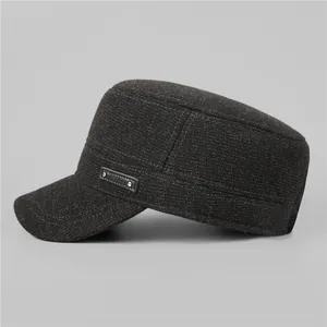 Detailed view of the dark textured fabric and fashion metal plaque on the winter flat cap