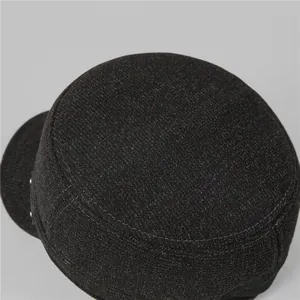 Macro detail of the gray wool flat top cap featuring thick texture and silver metal rivets