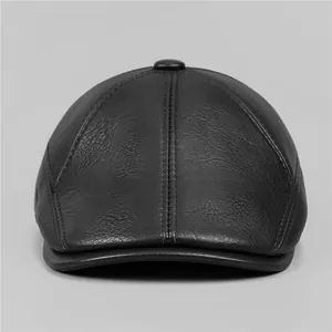 Detailed view of black leather flat cap showing fine stitching and top button texture