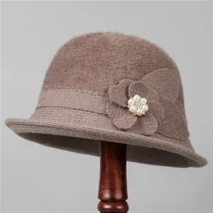 Detailed texture of brown knit bucket hat with pearl rhinestone flower embellishment