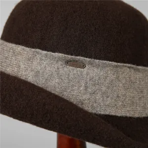 Detailed close-up of wool fedora hat featuring retro metal logo on knit decoration