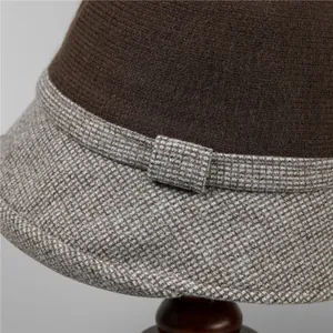 Dettaglio cappello a secchiello in lana con motivo pied de poule e fiocco decorativo