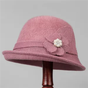 Detail of elegant knit bucket hat with dusty rose flower, pearl, and rhinestone decor
