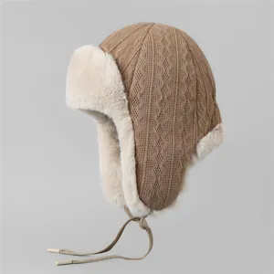 Détail du bonnet en maille torsadée avec doublure en fausse fourrure et cache-oreilles