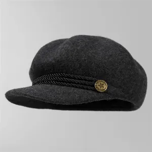 Vue détaillée du bonnet en laine grise avec cordon tressé et bouton étoile dorée