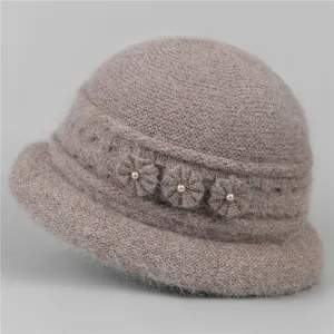 Detailed close-up of soft faux fur texture and elegant floral pearls on pink winter hat