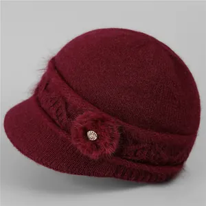 Detailed view of dark red knitted wool hat with side floral accent and soft plush texture