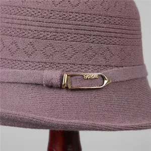 Detalle de gorro de pescador de punto morado con textura de ganchillo y hebilla