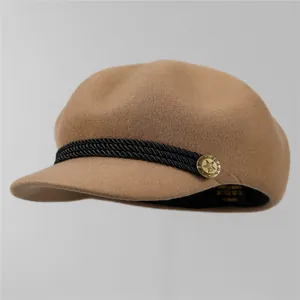Détail de la casquette en laine kaki avec corde tressée et bouton métallique doré vintage