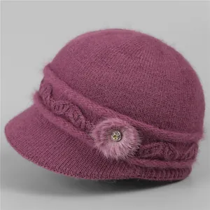 Detail of warm purple knit hat for elderly women with fur pompom and jeweled button