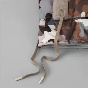 Detail der Camouflage-Wintermütze mit Kunstpelzbesatz und warmem grauem Fleece-Futter