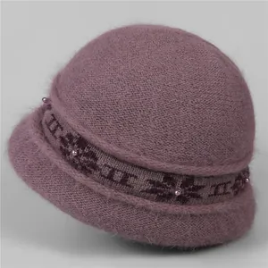 Detail of purple knitted winter hat featuring fluffy rabbit fur texture and pearl accents