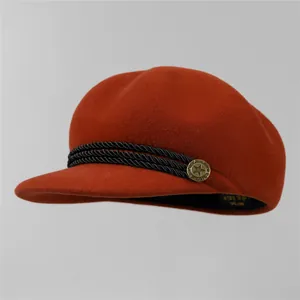 Détail de la casquette gavroche en laine avec bordure tressée et bouton en métal