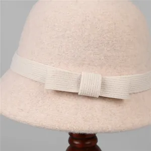 Elegant wool bucket hat in beige with decorative ribbon and bow detail for winter
