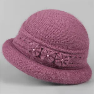 Close-up of deep purple winter knit hat featuring handcrafted flowers and pearls