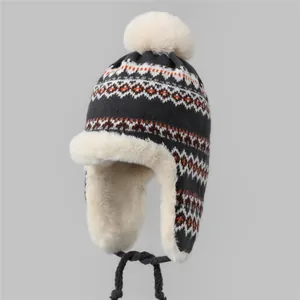 Détail d'un bonnet trappeur tricoté avec motif de flocon nordique et doublure en fourrure