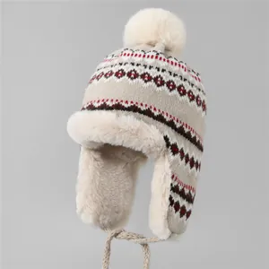 Détail du bonnet en maille beige avec motif nordique et doublure en fausse fourrure
