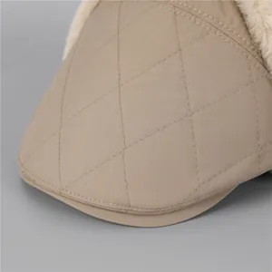 Gros plan détaillé du tissu matelassé kaki et de la doublure en peluche du chapeau