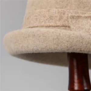 Detail shot of beige wool felt cloche hat showing texture and elegant ribbon bow