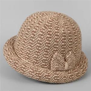 Detail of a thick brown and beige knit bucket hat with a stylish side bow decoration