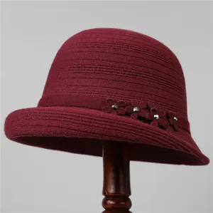 Dettaglio cappello a secchiello bordeaux in maglia con fiori e strass decorativi