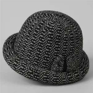 Detail of grey knitted cloche hat featuring thick warm fabric and side bow decoration