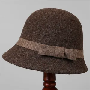 Detailed texture of dark brown wool felt hat with decorative ribbon and bow knot