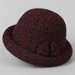 Detailed close-up of a women's warm knitted cloche hat with red black plaid and bow decoration