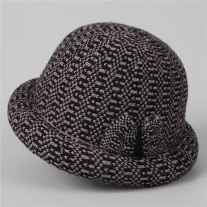 Close-up of winter knit hat for elderly women with purple floral weave and side bow