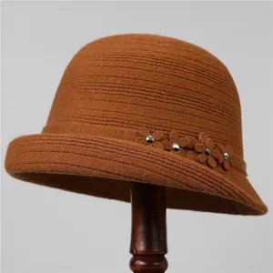 Dettaglio del cappello pescatore marrone in maglia con fiori 3D e strass argentati