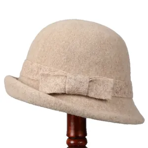 French vintage oatmeal wool felt cloche hat with an elegant bow on a wooden stand