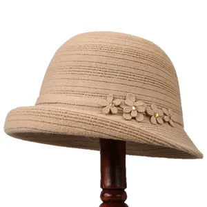 Elegante cappello cloche in maglia kaki per donna con fiori decorativi su supporto in legno