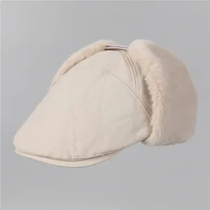 Détail du bonnet à oreillettes crème avec matelassage en losanges et doublure en peluche