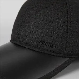 Detail of black sports cap featuring textured fabric and embossed leather-like brim